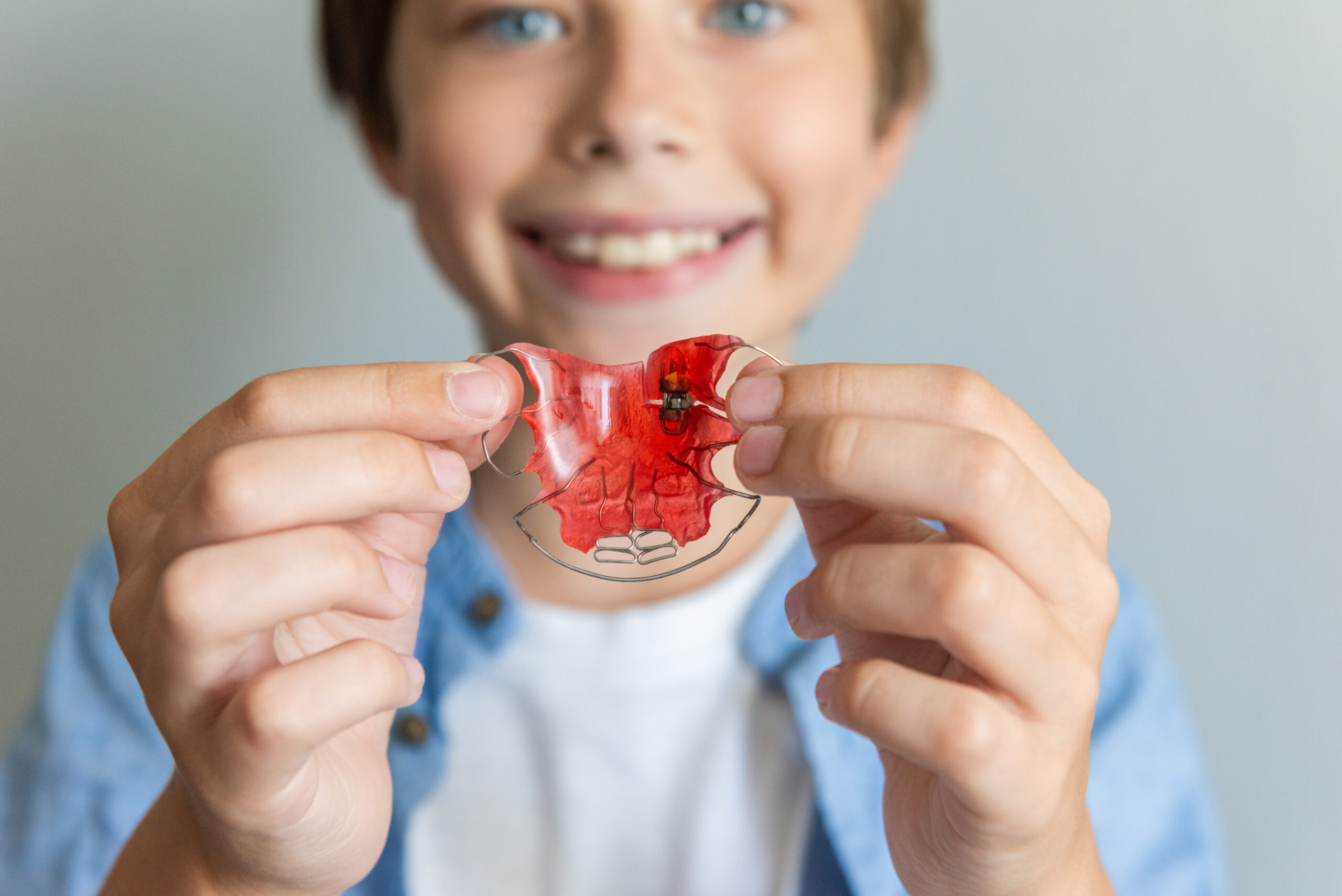 Child boy with Dental plate. Expansion of the jaw in a child. Color Orthodontic plate for children